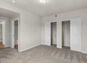 Thumbnail 13 of 45 - a bedroom with three closets and a carpeted floor
