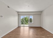 Thumbnail 11 of 45 - a bedroom with hardwood flooring and a sliding glass door leading to a balcony