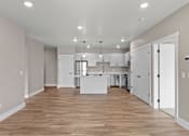 Thumbnail 11 of 48 - a kitchen and living room with a hardwood floor and white doors
