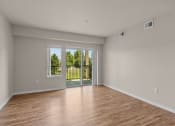 Thumbnail 45 of 45 - a bedroom with hardwood floors and a sliding glass door to a balcony