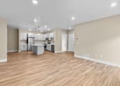 Thumbnail 15 of 48 - a spacious living room with a kitchen in the background