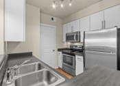 Thumbnail 16 of 45 - a kitchen with white cabinets and stainless steel appliances