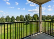 Thumbnail 20 of 45 - a balcony with a view of a grassy field and trees