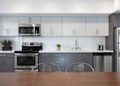 Thumbnail 12 of 28 - Apartments in Hollywood, CA for Rent - The Fifty Five Fifty - Kitchen with an Open Floor Plan, White Cabinets, and Stainless-Steel Appliances