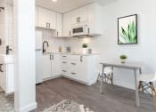 Thumbnail 6 of 12 - a kitchen with white cabinets and a white dining table with two white chairs