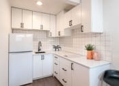 Thumbnail 11 of 12 - a kitchen with white cabinets and a white refrigerator
