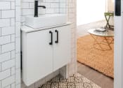 Thumbnail 9 of 12 - a small bathroom with white subway tile and a white sink with a black faucet