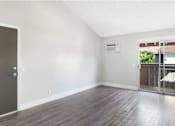 Thumbnail 9 of 24 - A room with a wooden floor and a door on the left.