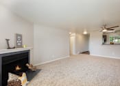 Thumbnail 6 of 20 - A living room with a fireplace and a carpet.