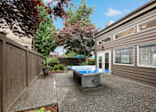 Thumbnail 14 of 20 - A table tennis table is placed on a concrete patio.