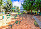 Thumbnail 16 of 20 - A playground with a green metal structure and a bench.