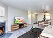 Thumbnail 1 of 20 - A living room with a fireplace and a television on a wooden stand.