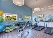 Thumbnail 13 of 20 - A gym with treadmills, exercise bikes, and weights.