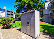 Thumbnail 17 of 20 - A grey portable toilet is placed on a concrete slab in a grassy area.