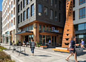 Thumbnail 18 of 20 - people walking on a sidewalk in front of a building