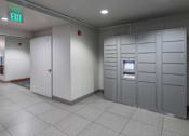 Thumbnail 22 of 29 - A row of grey lockers with a green exit sign above them.