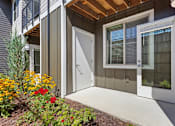 Thumbnail 34 of 34 - A white door is open to a small patio with a flower bed.