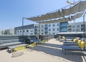 Thumbnail 5 of 33 - a roof deck with couches and chairs in front of a building with a crane in the