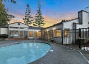 Thumbnail 14 of 39 - Novela Apartment Homes Pool Area and Clubhouse at Dusk