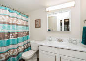 Thumbnail 35 of 39 - a bathroom with a white sink and toilet next to a shower with a blue and brown shower