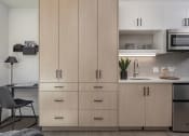 Thumbnail 20 of 33 - a kitchen with white cabinets and a white countertop with a sink and a microwave