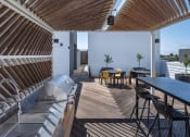 Thumbnail 1 of 33 - a rooftop deck with a grill and table and chairs
