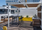 Thumbnail 4 of 33 - a pergola on a rooftop patio with a kitchen and dining area