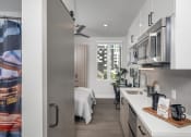 Thumbnail 26 of 33 - a kitchen with white cabinets and stainless steel appliances and a window with a view of a bedroom