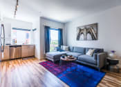 Thumbnail 16 of 21 - a living room with a blue rug and a gray couch at Wilcox, Seattle, 98107