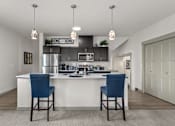Thumbnail 1 of 24 - A kitchen with a white counter and blue chairs.