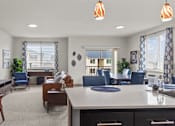 Thumbnail 4 of 24 - A well-lit room with a kitchen island and chairs.