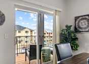 Thumbnail 6 of 24 - A dining room with a table and chairs and a view of a balcony.