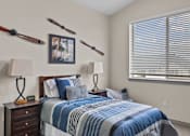 Thumbnail 8 of 24 - A bedroom with a bed, two lamps, and a picture on the wall.
