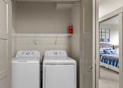 Thumbnail 9 of 24 - A small laundry room with a washer and dryer.