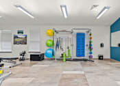 Thumbnail 18 of 24 - A gym with a variety of equipment including a squat rack, a bench, and a mirror.
