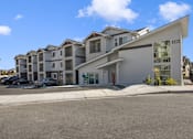 Thumbnail 1 of 34 - a row of apartment buildings with cars parked in front of them