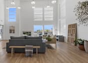 Thumbnail 13 of 34 - a living room with a gray couch and a dining room table