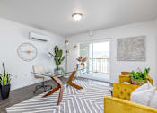 Thumbnail 17 of 34 - a living room with a glass desk and a yellow couch