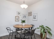 Thumbnail 18 of 34 - a dining room with a table and chairs and a potted plant