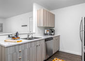 Thumbnail 19 of 34 - a small kitchen with a sink and a refrigerator