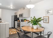 Thumbnail 21 of 34 - a kitchen and dining area with a table and chairs and a refrigerator