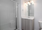 Thumbnail 26 of 34 - a bathroom with a shower and a sink and a mirror