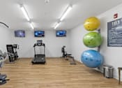 Thumbnail 31 of 34 - a gym with treadmills and other exercise equipment on a wood floor