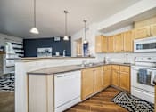 Thumbnail 2 of 47 - A kitchen with wooden cabinets and white appliances.