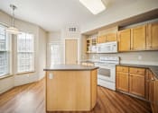 Thumbnail 4 of 47 - A kitchen with wooden cabinets and a white oven.