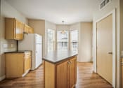 Thumbnail 6 of 47 - A kitchen with wooden cabinets and a refrigerator.