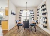 Thumbnail 9 of 47 - A dining room with a table and chairs.