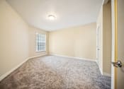 Thumbnail 13 of 47 - A room with a carpeted floor and a door on the right side.