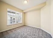 Thumbnail 16 of 47 - A room with a grey carpet and a window overlooking a building.