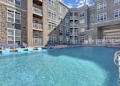 Thumbnail 7 of 23 - A large swimming pool in front of a multi-story residential building.